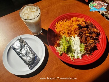 Plate of Eggs with Chorizo with guacamole, rice, burritos, and a glass of Horchata